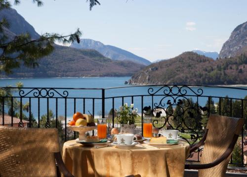 a table with food on it with a view of a lake at Hotel Miralago Wellness - Adults Only in Molveno