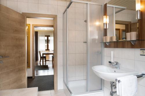 a bathroom with a sink and a glass shower at Apartments Gletscherblick in Kaprun