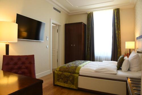 a hotel room with a bed and a television at Kleiner Rosengarten in Mannheim