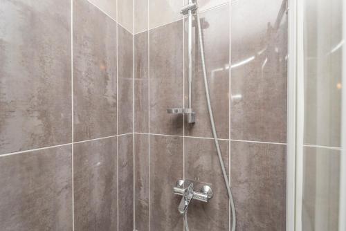 a shower with a shower head in a bathroom at Enna house with private jacuzzi in Novalja