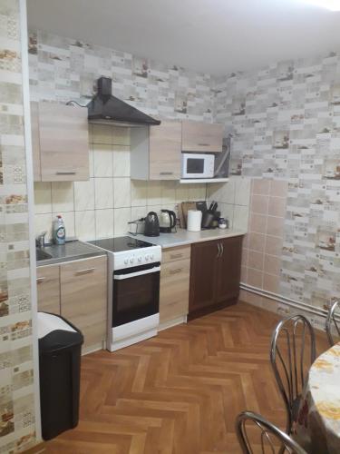 a kitchen with a stove and a microwave at Ginto nakvynės namai in Vilnius