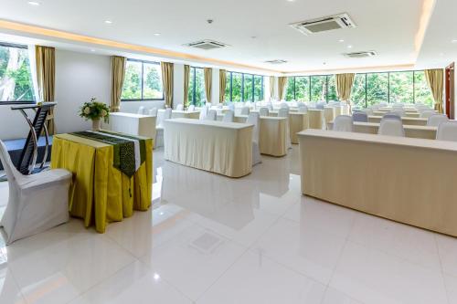 a room with white tables and white chairs at Ozone Hotel Khao Yai in Mu Si