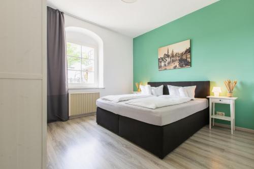 een slaapkamer met een groot bed met een blauwe muur bij Schloß Sonnenstein in Pirna
