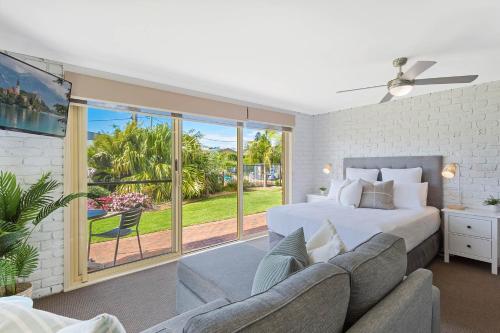 a bedroom with a large bed and a couch at Lakeside Holiday Apartments Merimbula in Merimbula