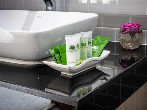 a bathroom counter with a bath tub and a sink at Ozone Hotel Khao Yai in Mu Si