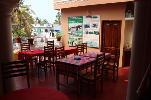a restaurant with tables and chairs with red and blue tablecloths at Bastian Homestay in Cochin