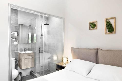 a bedroom with a shower and a bed and a sink at Endless sea view house in Nea Iraklia