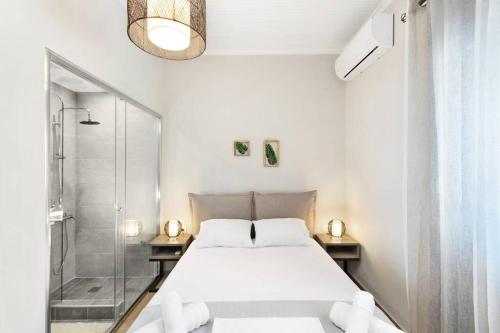 a white bedroom with a bed and a shower at Endless sea view house in Nea Iraklia