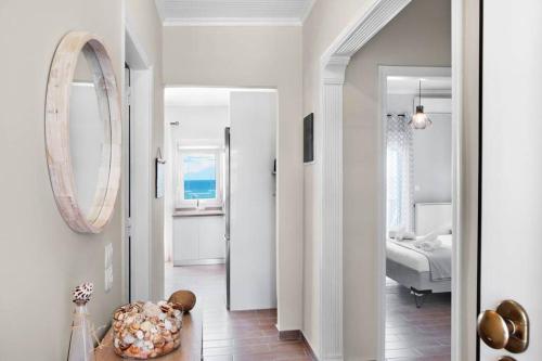 a hallway with a room with a bed and a mirror at Endless sea view house in Nea Iraklia