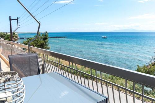 a table and chairs on a balcony overlooking the ocean at Endless sea view house in Nea Iraklia