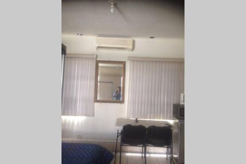 a room with two chairs and a table and a mirror at Valle de Brisas in Monterrey