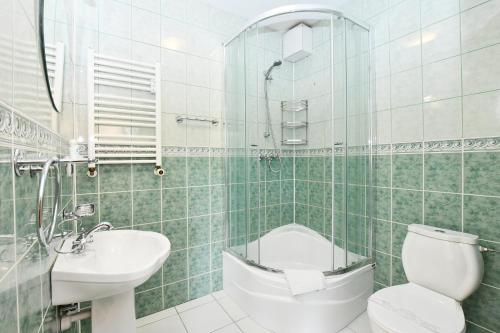 a bathroom with a toilet and a sink and a shower at Apartament 14A in Kołobrzeg