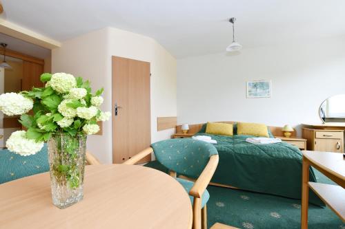 ein Zimmer mit einem Tisch mit einer Blumenvase darauf in der Unterkunft Apartament 14A in Kołobrzeg