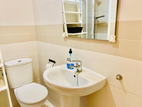 ein Badezimmer mit einem weißen WC und einem Waschbecken in der Unterkunft Fuengirola, Playa Carvajal in Fuengirola