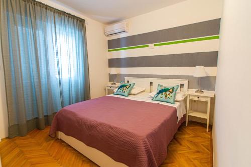 a bedroom with a bed with a striped wall at Villa Volga in Jelsa