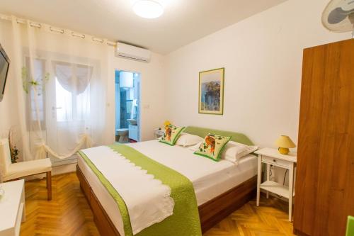 Villa Volga في ييلسا: غرفة نوم بسرير كبير مع بطانية خضراء