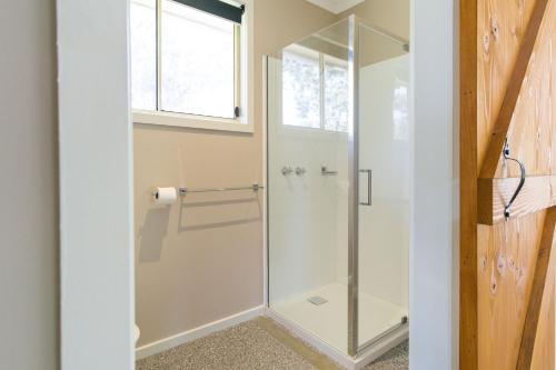 a glass shower in a bathroom with a window at Studio 165 Hidden Gem on 50 acres with bay views in Grantville