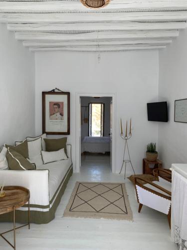 ein weißes Wohnzimmer mit einem Sofa und einem Tisch in der Unterkunft Serifos Olive in Serifos Chora