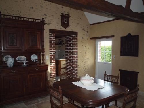 a dining room with a table and a fireplace at Gîtes les Terriers in Saint-Jean-Froidmentel