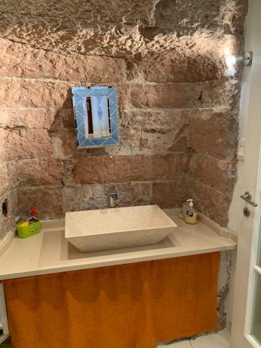 a bathroom with a sink and a brick wall at Apartments Aurora Delle Rose in Assisi