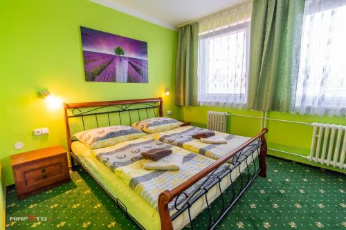 a bedroom with a bed in a green room at Hotel Hvězda in Kroměříž