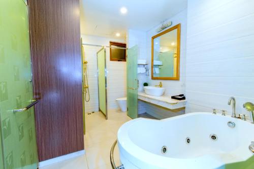 a bathroom with a tub and a sink and a mirror at Hoa Dao Hotel in Hòa Bình