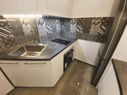 
a kitchen with a sink, stove, and refrigerator at Premium Crown Suites in Belgrade
