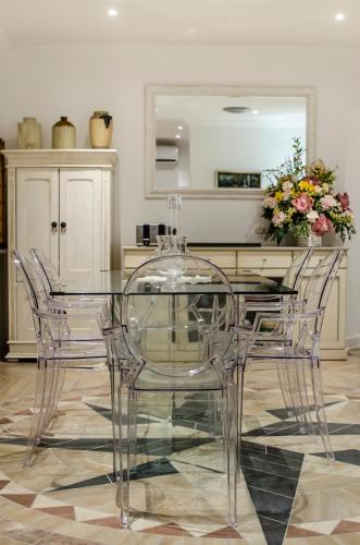 a glass dining table and chairs in a room at Somerset View Guest House in Somerset West