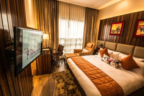 a hotel room with a bed and a flat screen tv at Regenta Central Amritsar in Amritsar