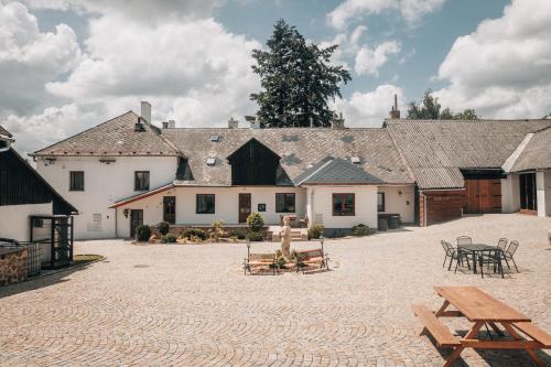 a large courtyard with tables and benches in front of a building at Apartmán v přírodě pro 4 osoby in Jihlava