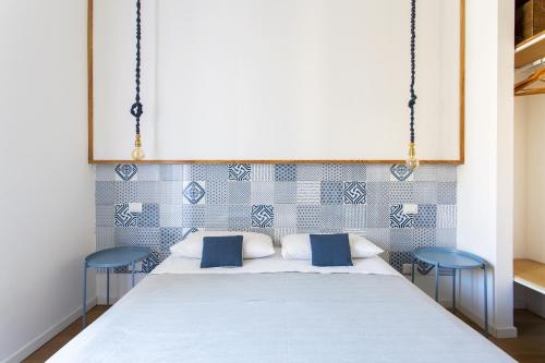 um quarto com uma cama com 2 cadeiras azuis em Canceddi Rooms em Palermo