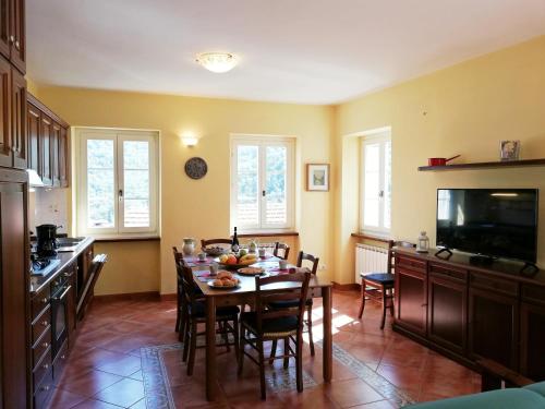 a kitchen with a table with chairs and a television at Case Vacanze Borgo Faraldi in Villa Faraldi