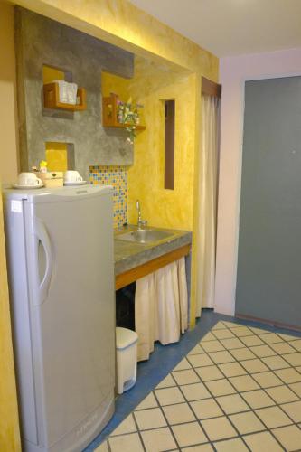 a kitchen with a sink and a white refrigerator at The Weenee Boutique in Hat Yai
