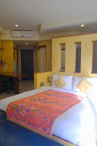a bedroom with a large white bed with a red blanket on it at The Weenee Boutique in Hat Yai