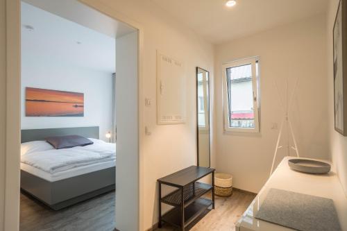 a small bedroom with a bed and a mirror at Ferienwohnung Montfort in Langenargen