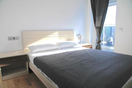 ein Schlafzimmer mit einem großen Bett und einem Fenster in der Unterkunft Sotell Apartment Gran Via Europa BCN in Las Corts