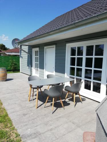 a table and chairs on a patio in front of a house at Ostseeperle in Grömitz