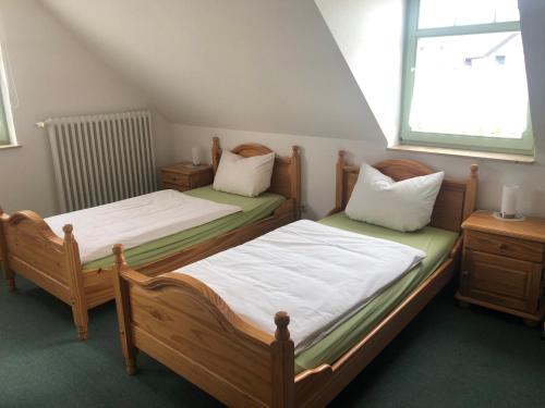 two twin beds in a room with a window at Pension Zur Linde in Berlstedt