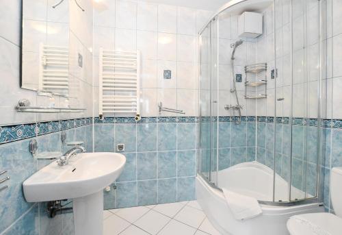 a bathroom with a sink and a toilet and a tub at Apartament 14B in Kołobrzeg