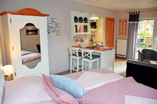 1 dormitorio con 1 cama y cocina pequeña en Ferienwohnung Familie Haensel en Baabe