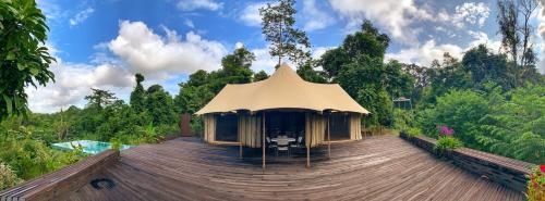 a building with a tent on a wooden deck at Sepilok Forest Edge Resort in Sepilok