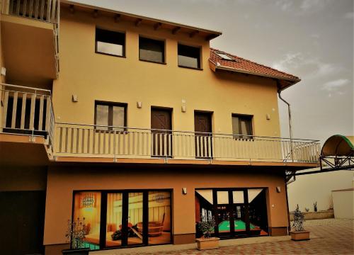 a large house with a balcony on top of it at Termál Apartmanház in Veresegyház