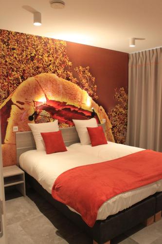 a bedroom with a large bed with red pillows at Vakantiewoning Atuatuca in Tongeren