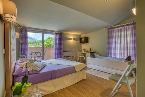 a bedroom with a bed and a tub in it at Hotel Des Reves in SantʼElia Fiumerapido