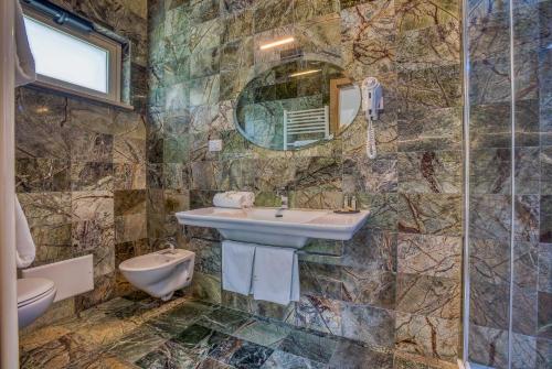 a bathroom with a sink and a toilet and a mirror at Hotel Des Reves in SantʼElia Fiumerapido