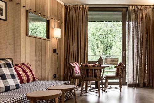 a living room with a bed and a table and chairs at Eden Hotel in Bormio