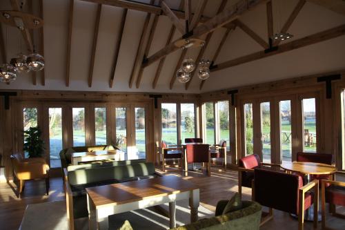 a restaurant with tables and chairs and windows at Ivy House Country Hotel in Lowestoft