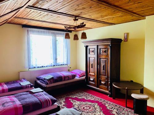 Cette chambre comprend 2 lits, une table et une fenêtre. dans l'établissement Guesthouse Prachovské skály, à Blata