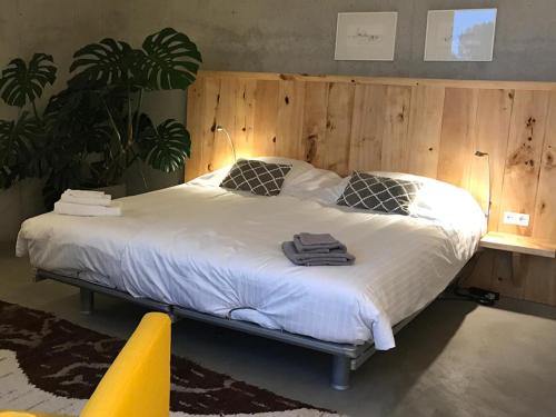 een slaapkamer met een groot bed en een houten muur bij MOoij Bed en Breakfast in Ooij