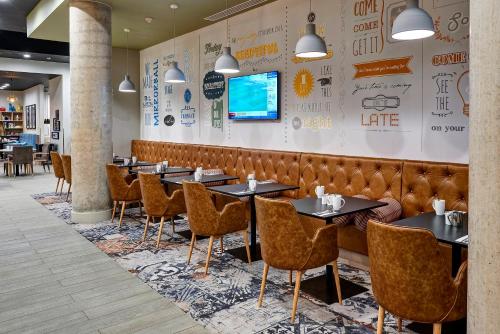 a row of tables and chairs in a restaurant at Holiday Inn Manchester - City Centre by IHG in Manchester
